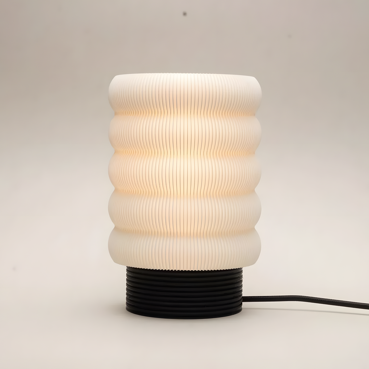 Luminária Argola Longa, luminária impressa em 3D da Éttore Decor, acesa em fundo neutro